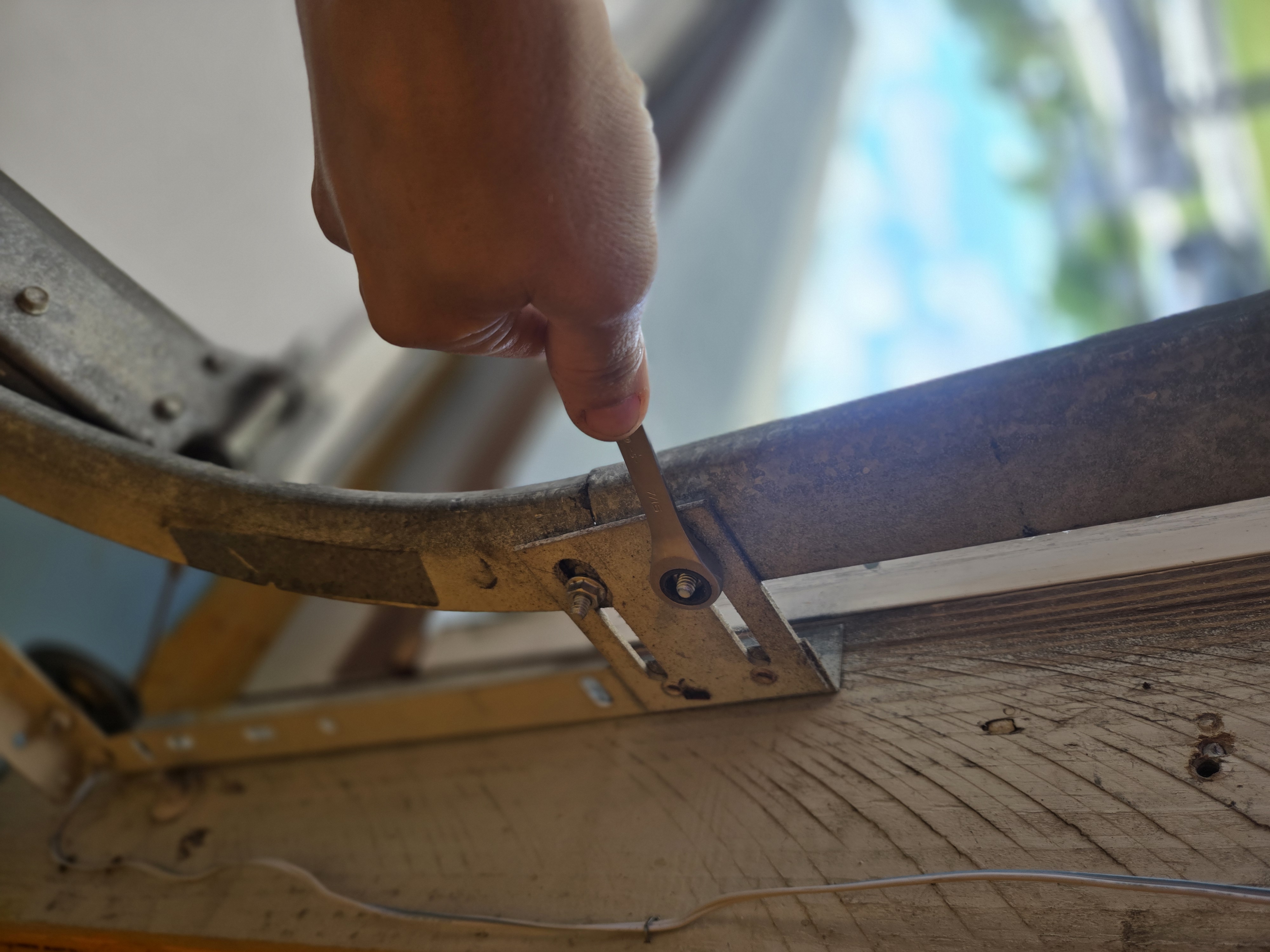Technician tightening garage door hardware to keep the door safe and secure