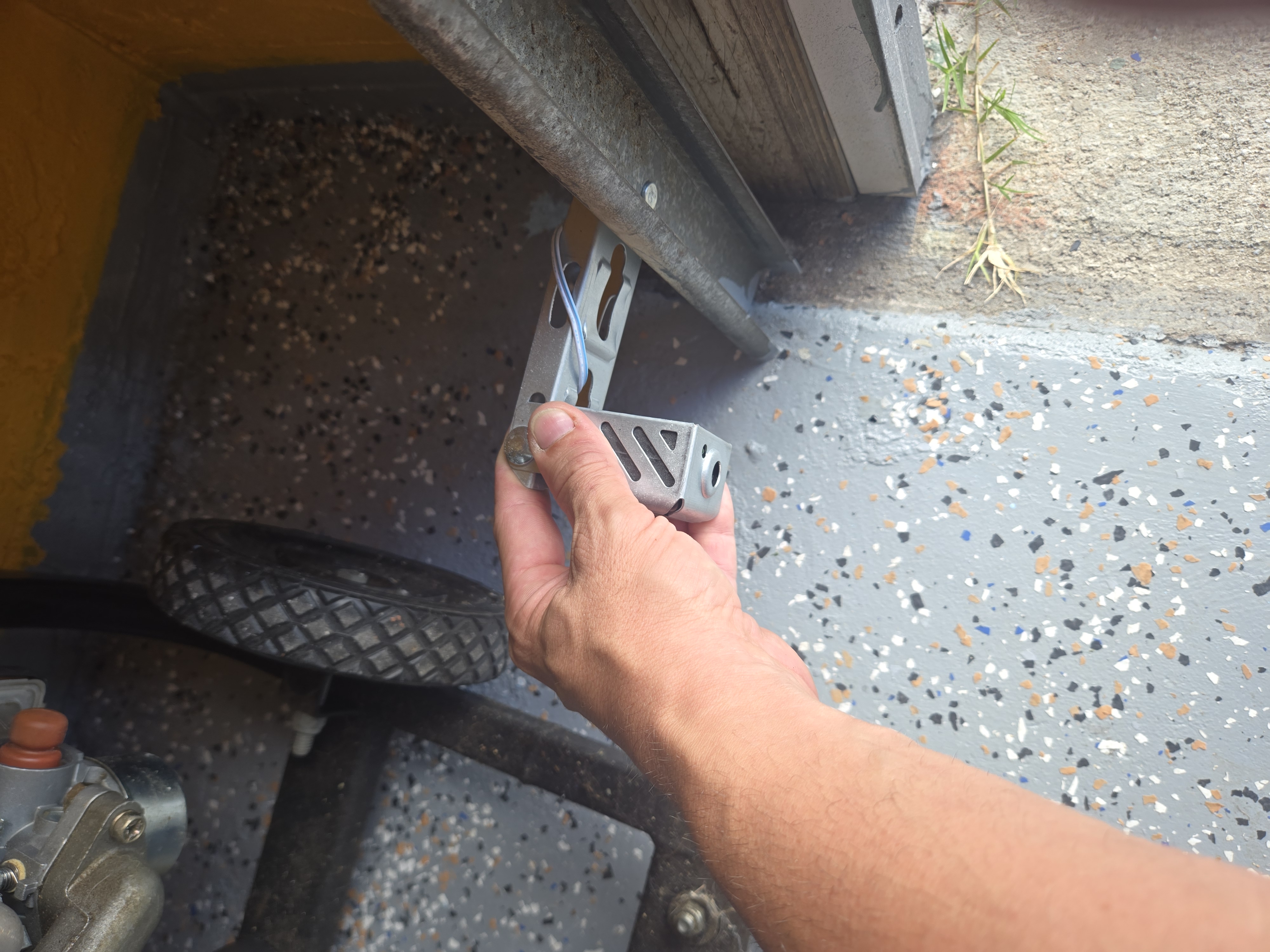 Garage door safety sensor being checked for proper alignment